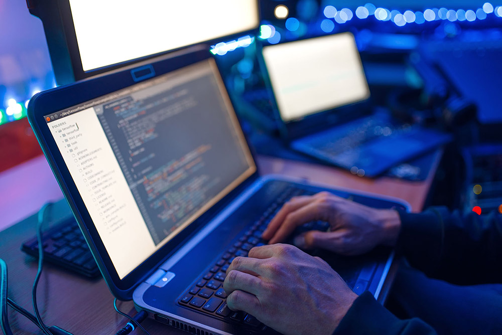 Programmers hands on laptop keyboard