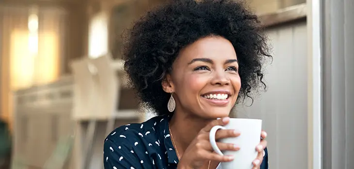 Female smiles while drinknig coffee